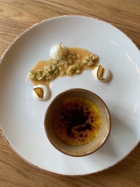 En benvit tallrik med en mindre skål på med creme brulee