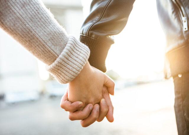 couple holding hands at arch du triomphe