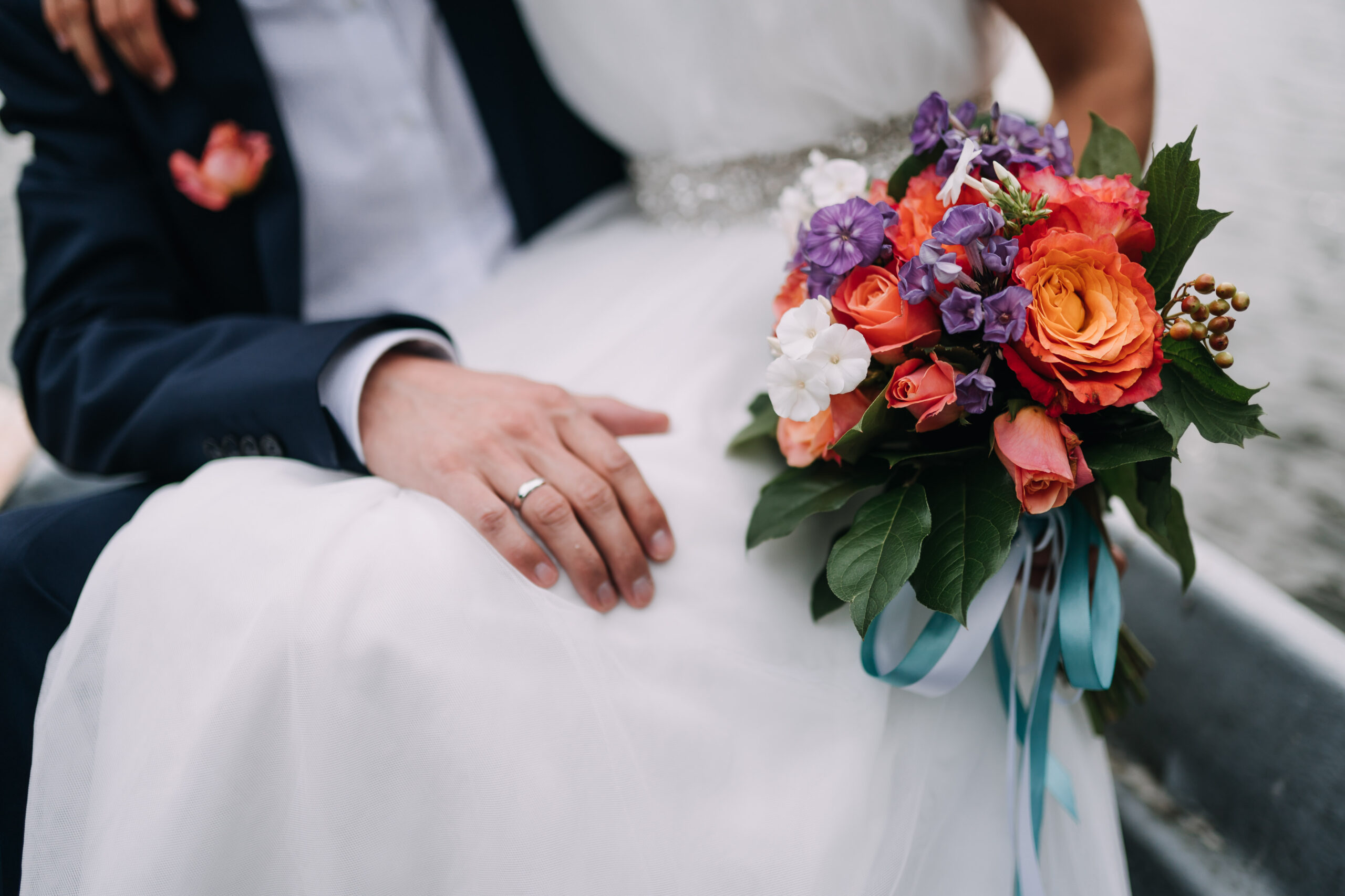 a groom and a bride holding a bouquet